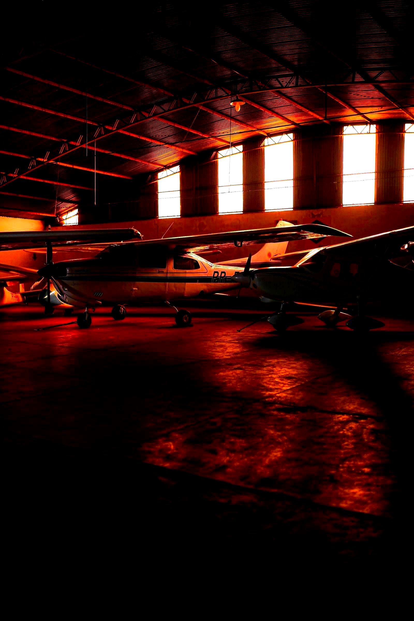 Commercial aircraft lined up inside a large manufacturing hangar facility